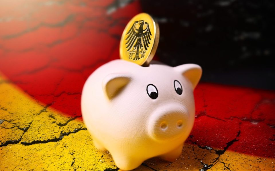 Einspar-Schein mit einer deutschen Münze, im Hintergrund eine deutsche Flagge